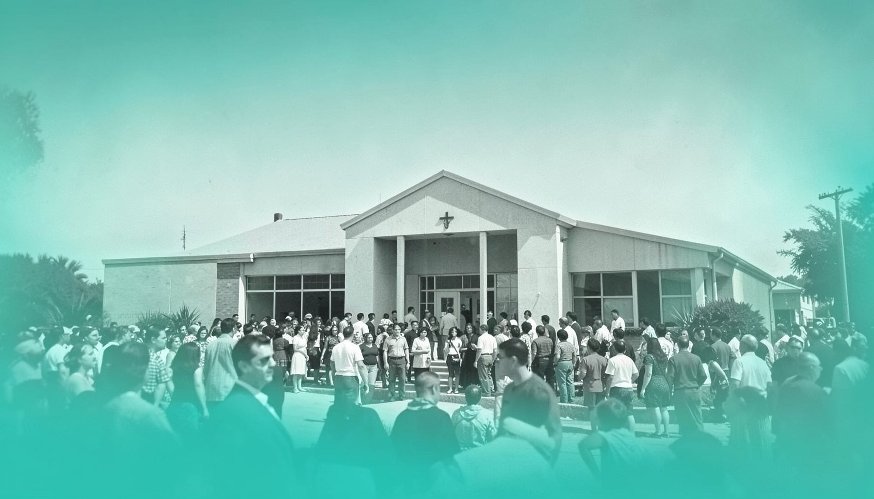 A vintage black-and-white photograph of a congregation gathered outside a mid-century church building under a wide Texas sky, suggesting heritage and continuity